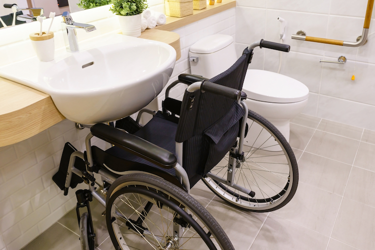disabled bathroom with wheelchair near the sink