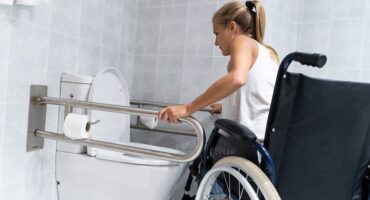 disabled girl holding on rails toilet