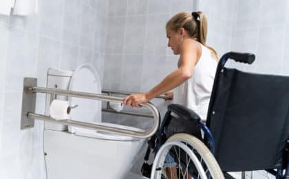 disabled girl holding on rails toilet