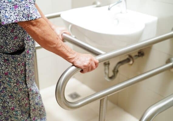 elderly woman using sink grab rails