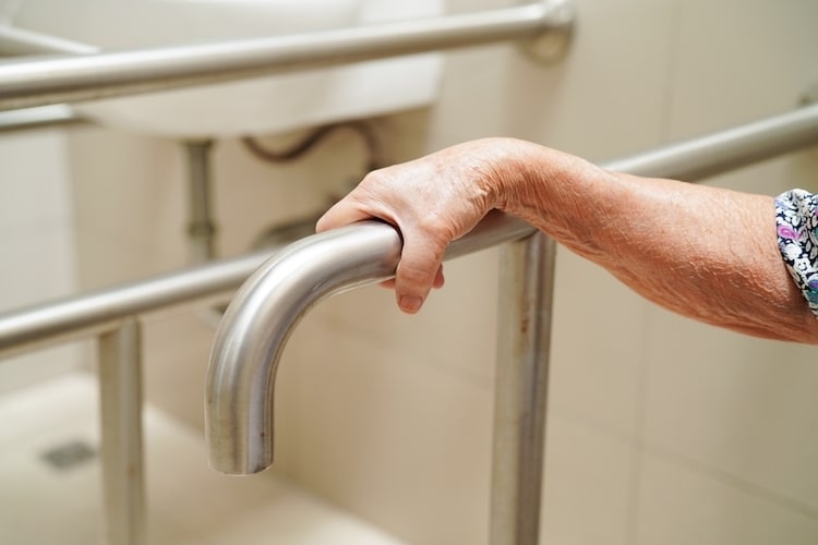 old woman grabbing hand rail