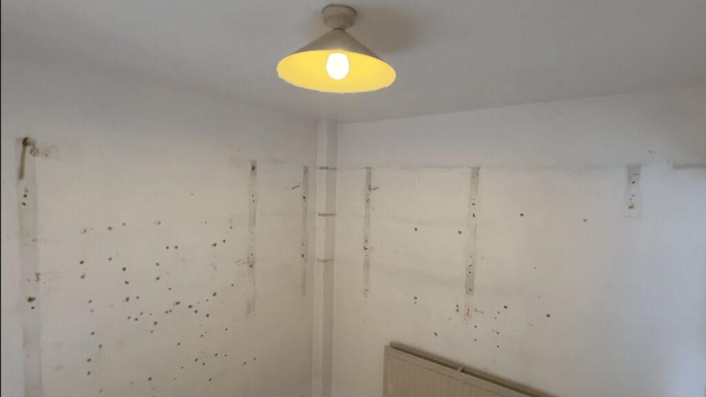 The former study before the work, stripped back to bare plastered walls with no plumbing in place.