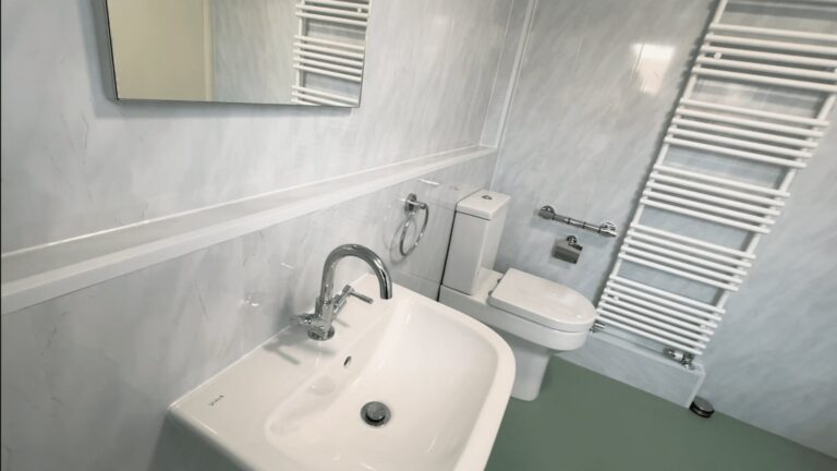 Helen's finished wheelchair-accessible wet room, with a level-access shower, half-height doors, basin and toilet