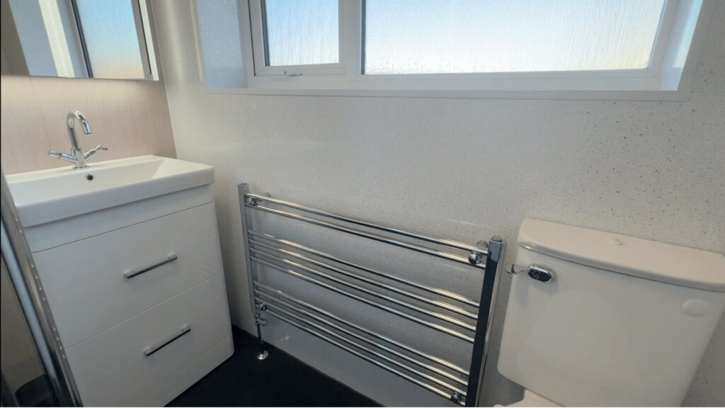 Julie's waterproof vanity unit, comfort-height toilet and LED mirror in the finished wet room