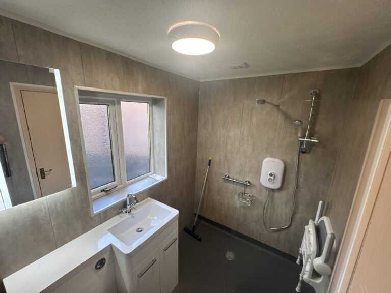 Brian's finished wet room: level shower area with anti-slip floor, glass screen, vanity basin and toilet.