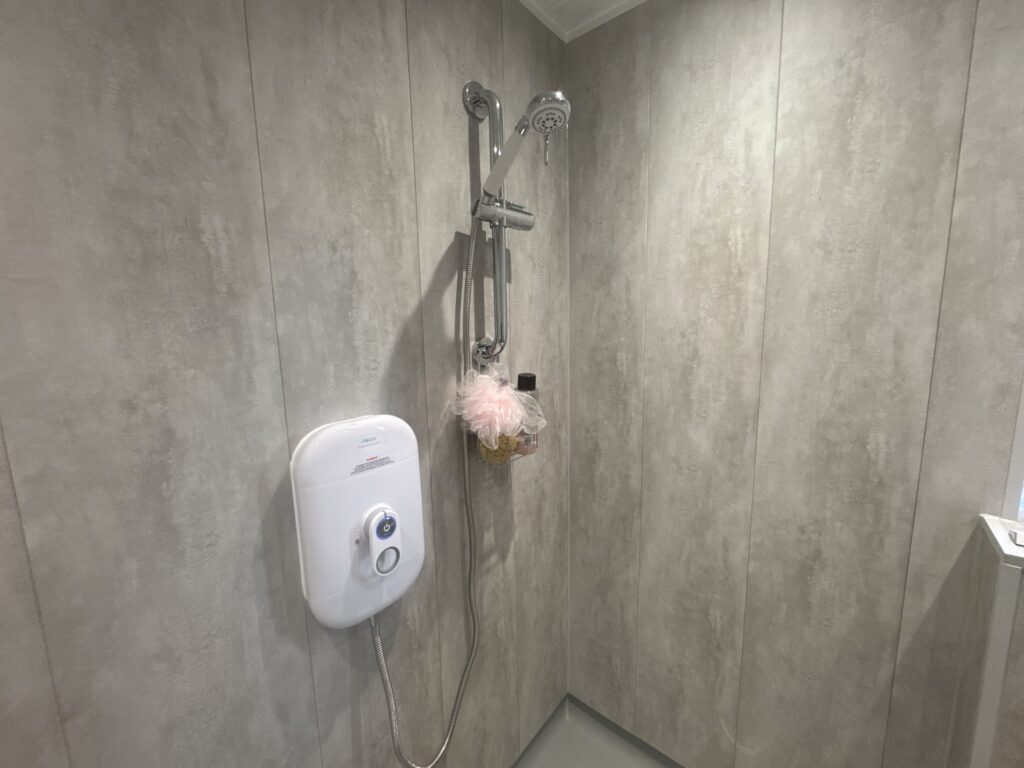 Linda's easy-to-use electric shower with a lever control, riser rail and handheld head