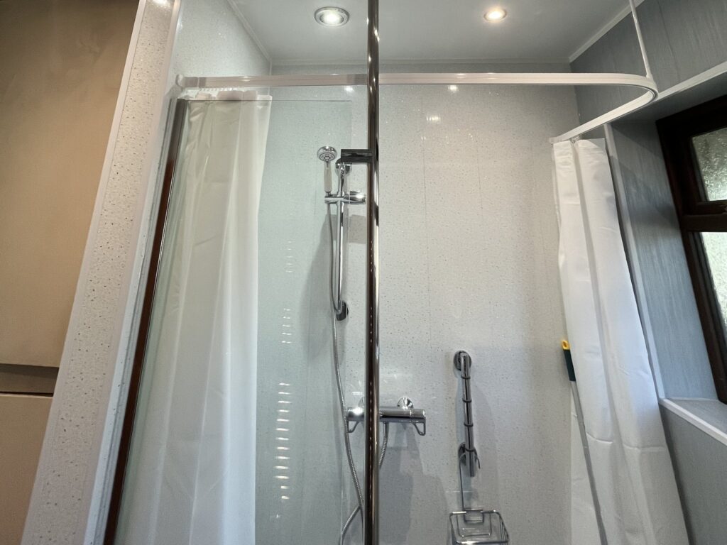 The thermostatic shower and handheld head in Bruce's wet room, with the curtain track above