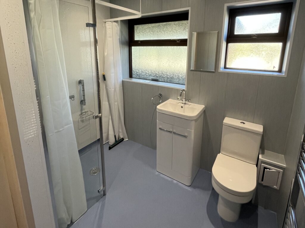 Bruce's finished wet room: level shower area with glass screen, vanity basin, toilet and slip-resistant flooring
