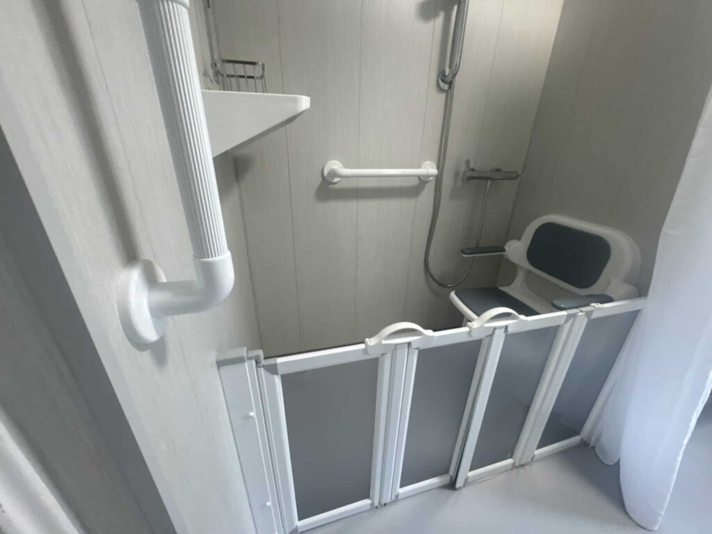 The shower in Room 1, with half-height folding doors that let a carer help from outside