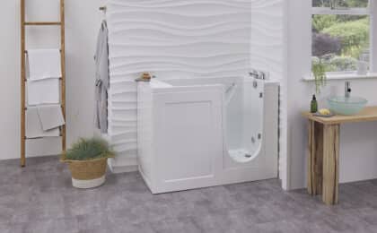 Walk-in bath with clear glass door and built-in seat in a modern bathroom
