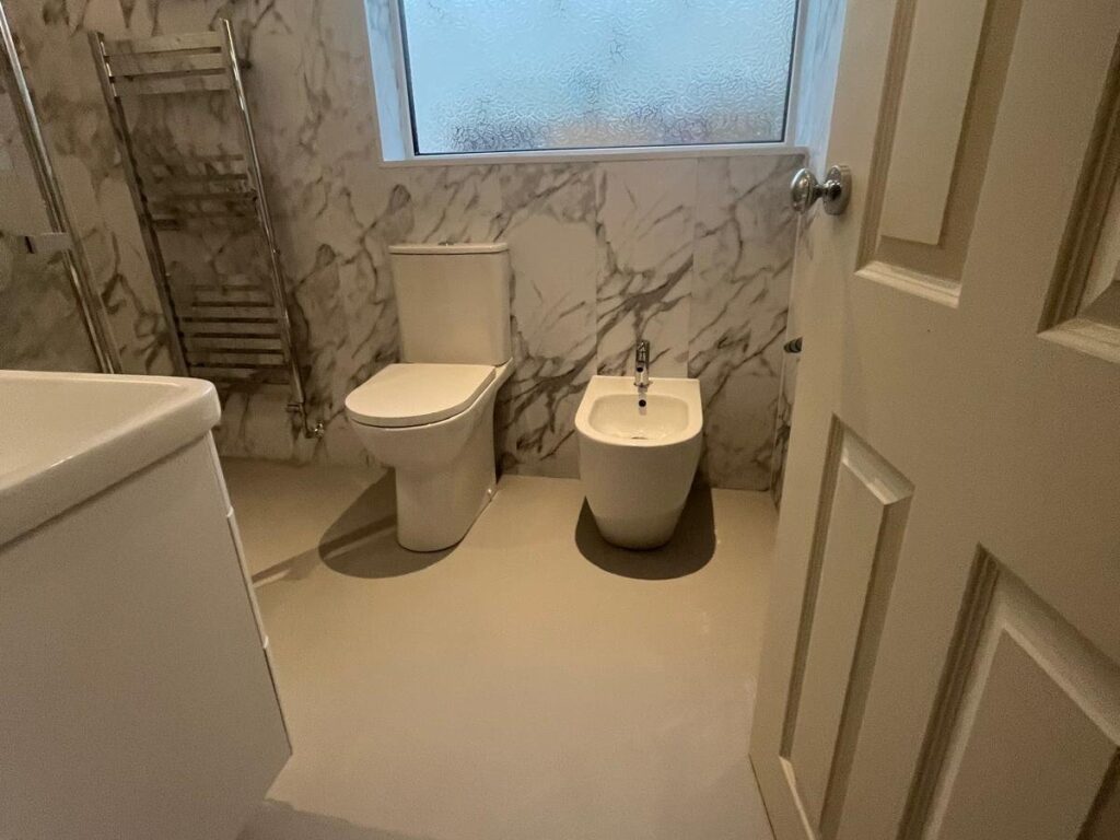 Lesley's matching toilet and bidet set beneath the window, with a heated towel rail alongside.