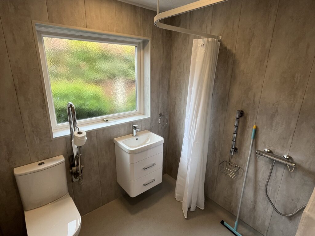 Across Mark's wet room: curtain track, thermostatic shower, vanity basin and toilet