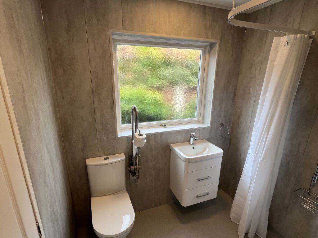 Mark's finished wet room: vanity basin, supported toilet and level floor, with the shower behind the curtain.