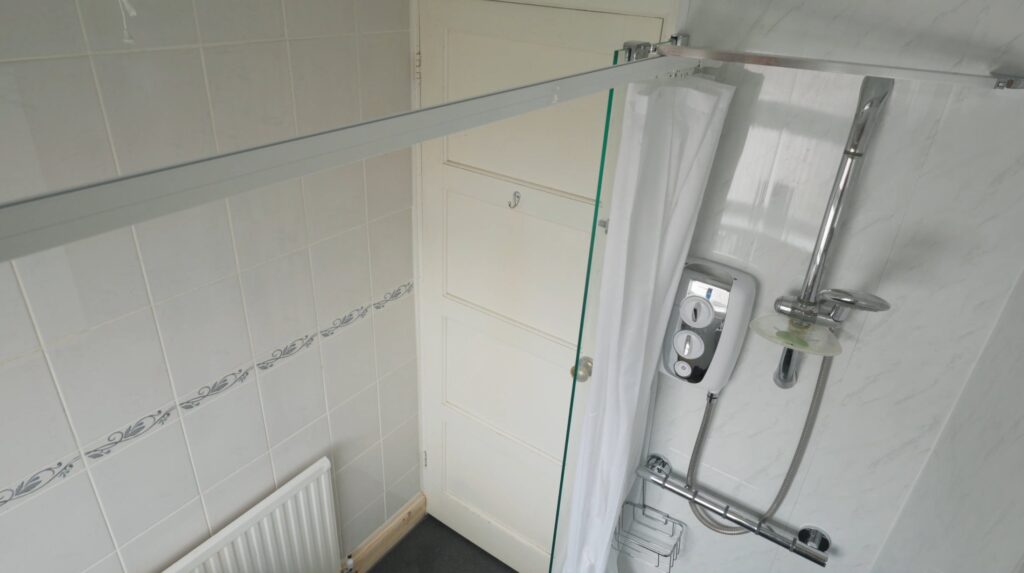 A wider view of Peter's finished wet room, with the level floor, glass screen and curtain track