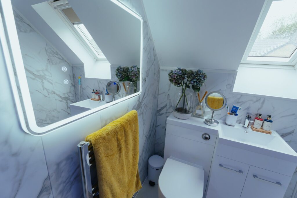 The illuminated mirror and skylights in Sophie's wet room, with the heated towel rail below.
