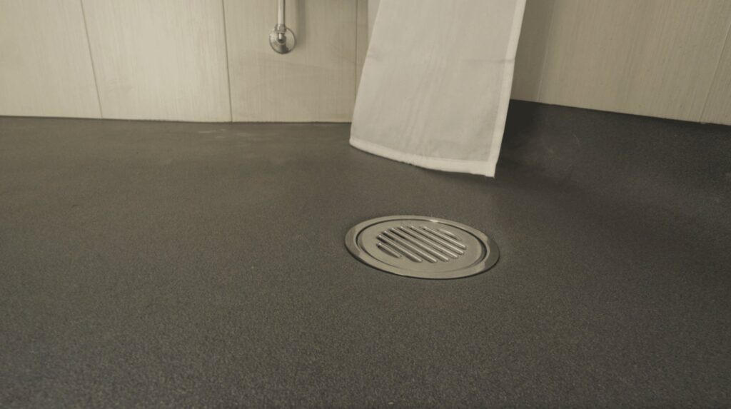 The flush floor drain in Kate's wet room, showing the fully level, step-free access.