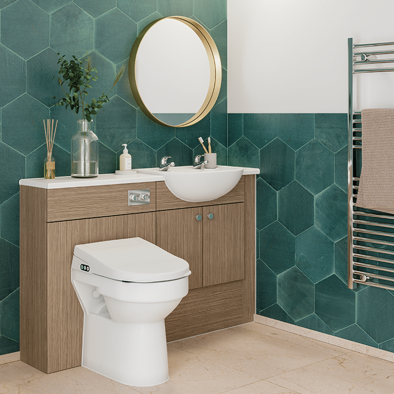 A modern accessible bathroom featuring a wash-and-dry bidet toilet, a semi-recessed washbasin, and a wood-effect vanity unit set against vibrant green hexagonal wall tiles, showcasing smart toilet technology available from Age Care Bathrooms.