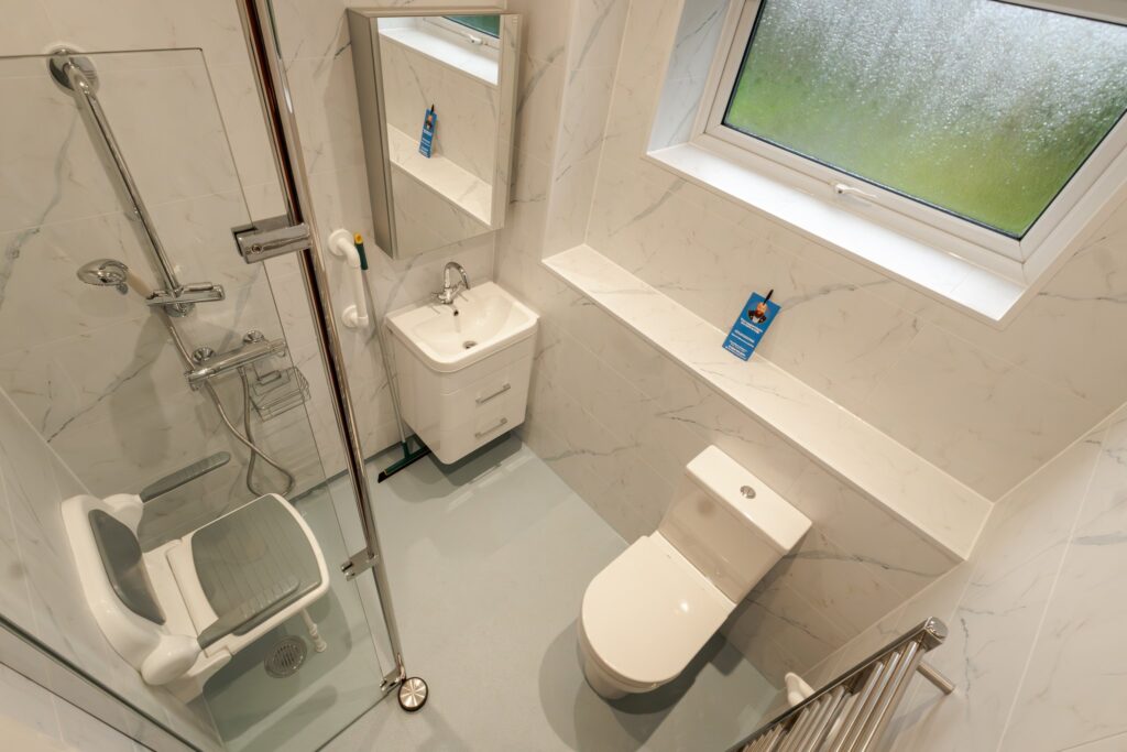 Dominic's finished wet room: level-access shower with grab rails and fold-down seat, toilet and easy-reach sink.