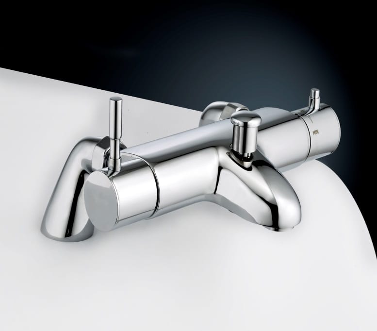A detailed, close-up product photograph of a modern, polished chrome thermostatic mixing valve bath and shower mixer tap, viewed from a slightly elevated angle against a white countertop and dark gradient background. The tap features a central body with a front spout and a pull-up diverter knob. Flanking the spout are two slender, vertical cylindrical handles. The right handle, controlling temperature, shows distinct ridged markings and a horizontal temperature scale, with the word 'MIN' and other markers clearly visible on the end cap.