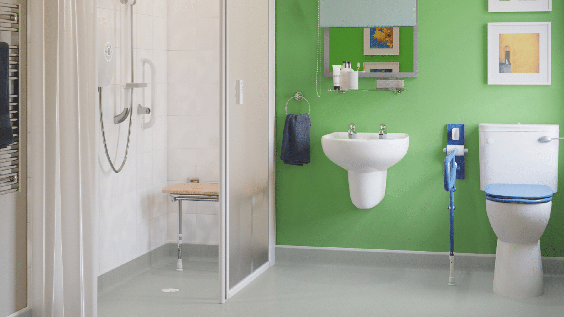 A modern accessible bathroom featuring a vibrant green accent wall and grey anti-slip flooring. The room includes a level-access shower with a wooden fold-down seat, a white pedestal sink, and a toilet with a high-contrast blue seat and matching blue drop-down grab rail.