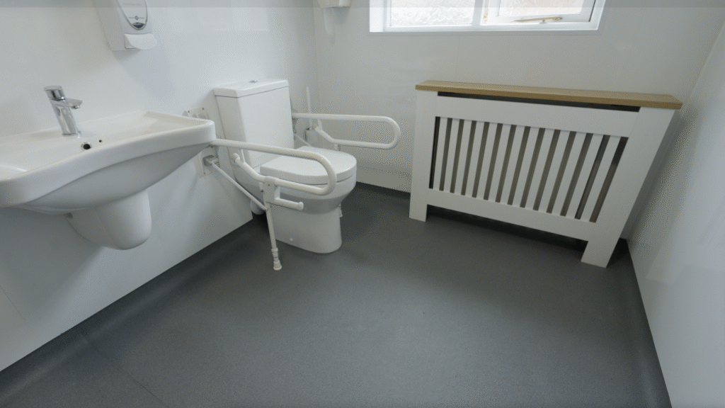 Stella's new toilet with drop-down support arms on both sides, giving stability exactly where it's needed.