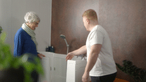 Still image of Sam (Director) talking to a customer during the Age Care Bathrooms TV advert.