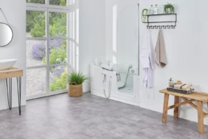 The Easy Riser walk-in bath with shower screen and seat lowered, in a bright bathroom
