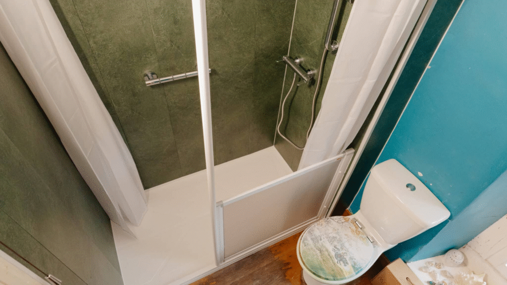 Walk-in shower with a low-profile tray installed by Age Care Bathrooms, with a grab rail, thermostatic shower and half-height screen.