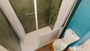 Walk-in shower with a low-profile tray installed by Age Care Bathrooms, with a grab rail, thermostatic shower and half-height screen.