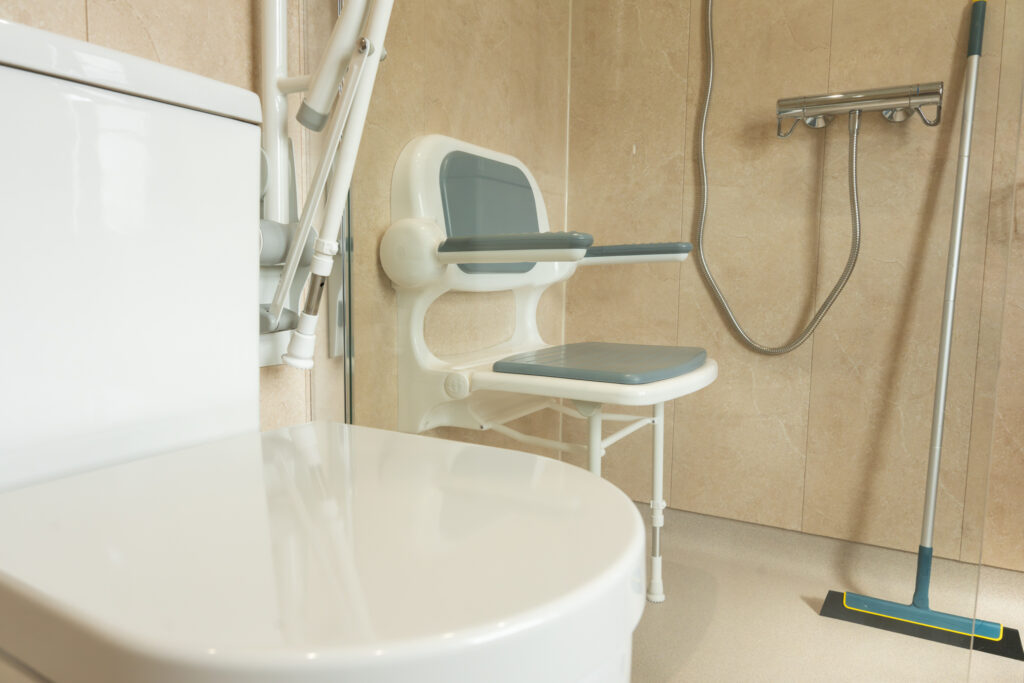 The padded folding shower seat in Elena's wet room, with the thermostatic shower alongside.