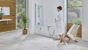 A woman in a robe beside the Montana walk-in bath with its low door closed