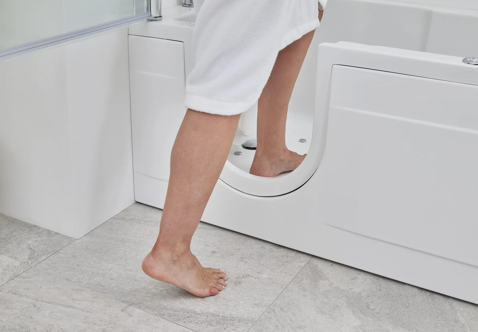 Close-up of a person stepping over the low threshold into the Montana walk-in bath