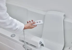 Close-up of a hand holding the Montana's powered seat control, marked seat up and seat down