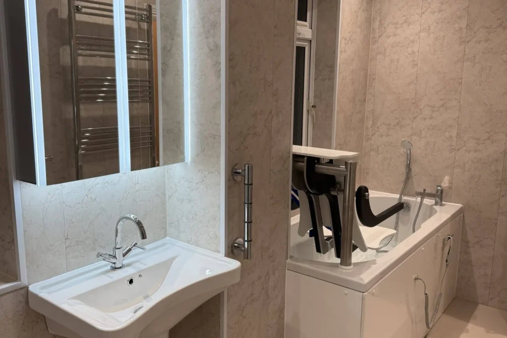 Clare's accessible bathroom with a walk-in bath, powered seat lift and grab rail