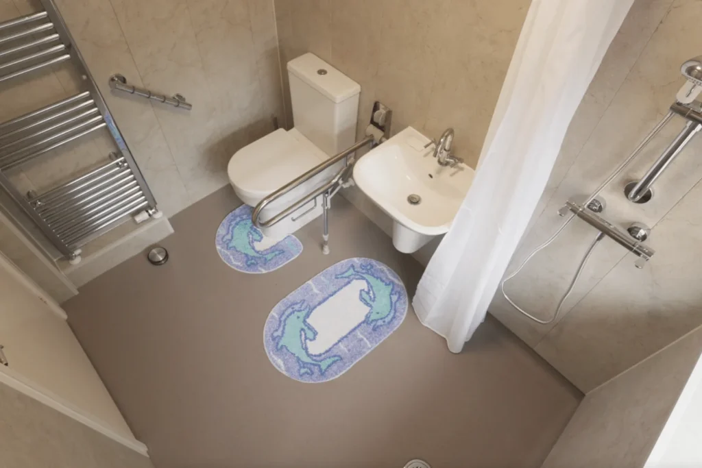 Julie's level-access wet room with grab rails, toilet and basin