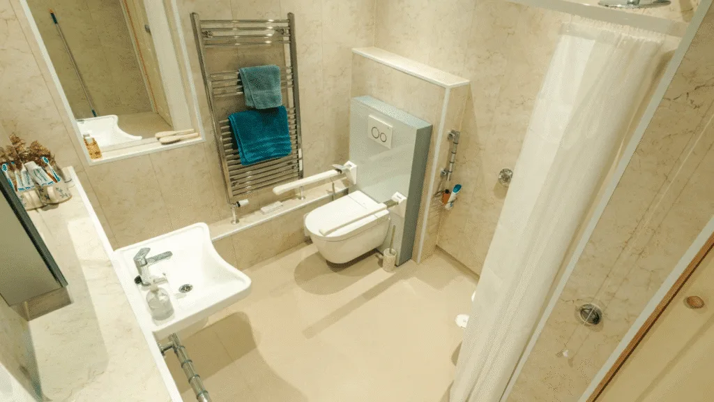 Olivia's spacious level-access wet room with a walk-in shower, grab rails, toilet and basin