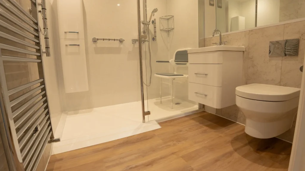Walk-in shower by Age Care Bathrooms with a low-profile tray, fold-down seat and supportive grab rails.