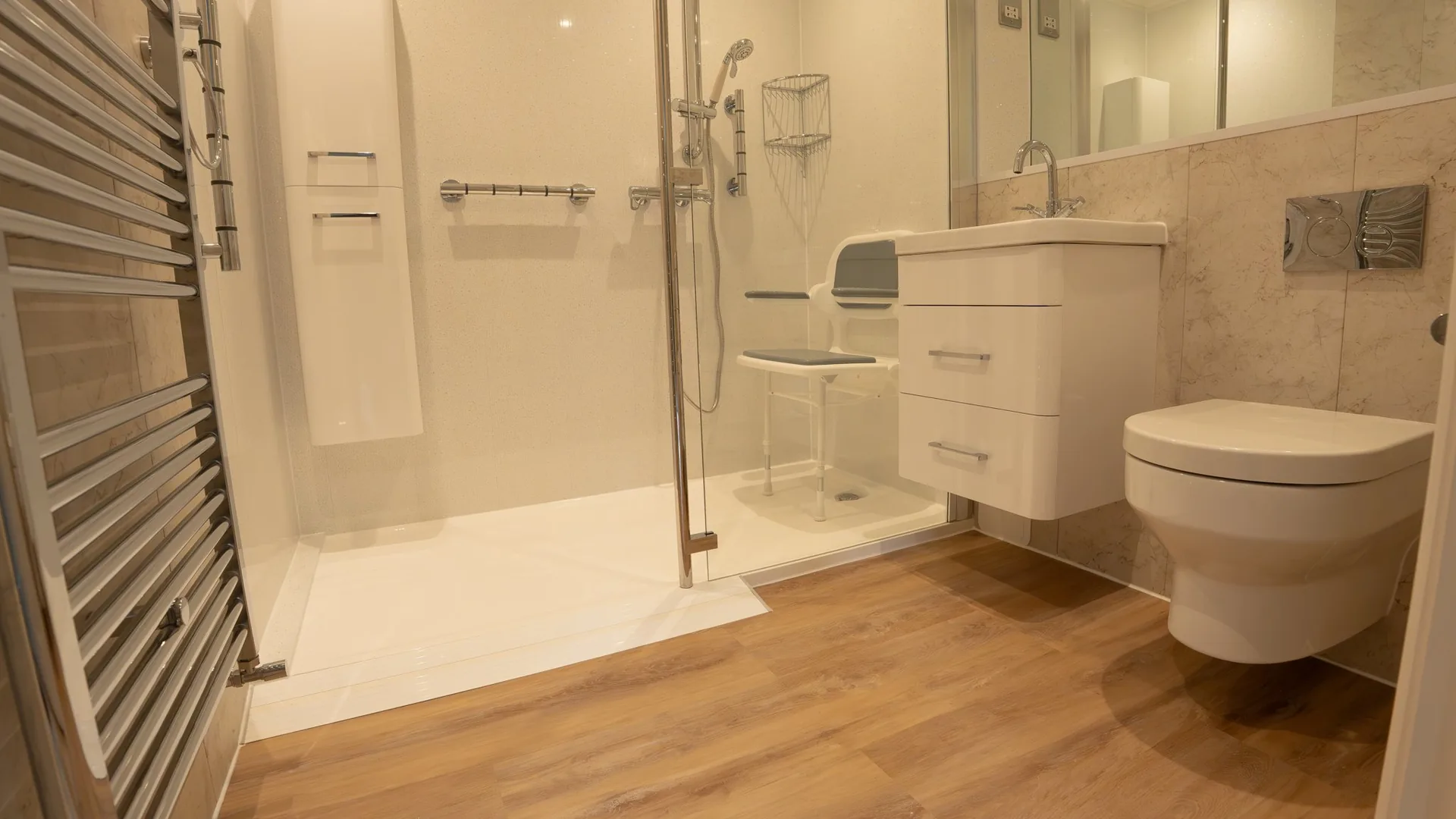 Walk-in shower by Age Care Bathrooms with a low-profile tray, fold-down seat and supportive grab rails.