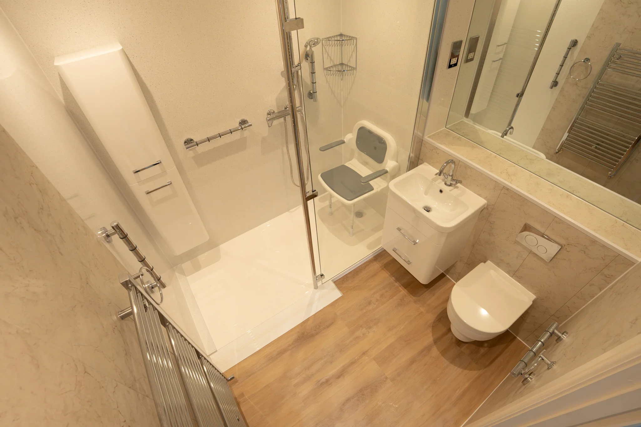 Maya's low-level walk-in shower, with grab rails, a shower seat, and wood flooring.