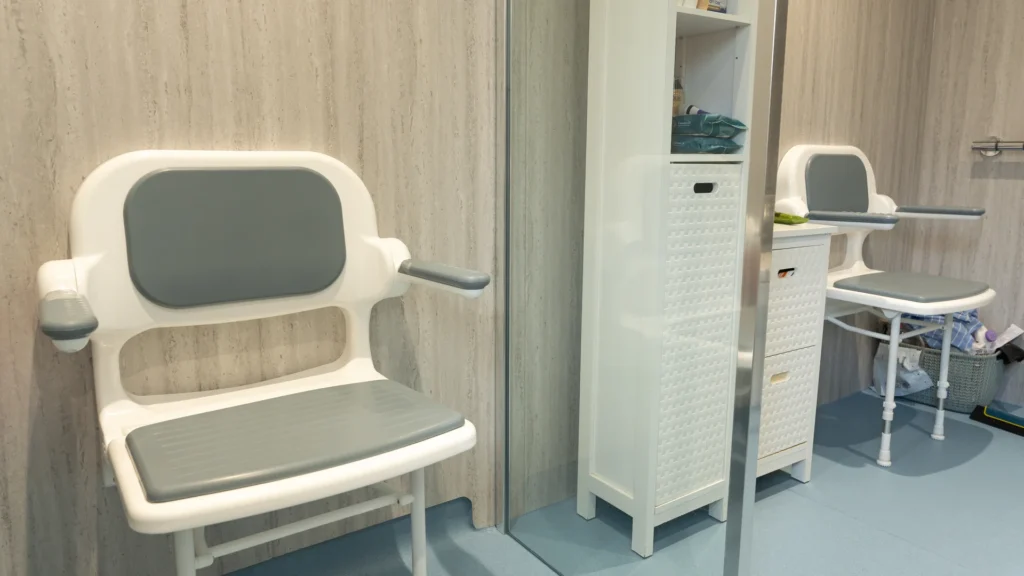 Two fold-down shower seats in Charlotte's wet room, on "Sea Urchin" slip-resistant floor