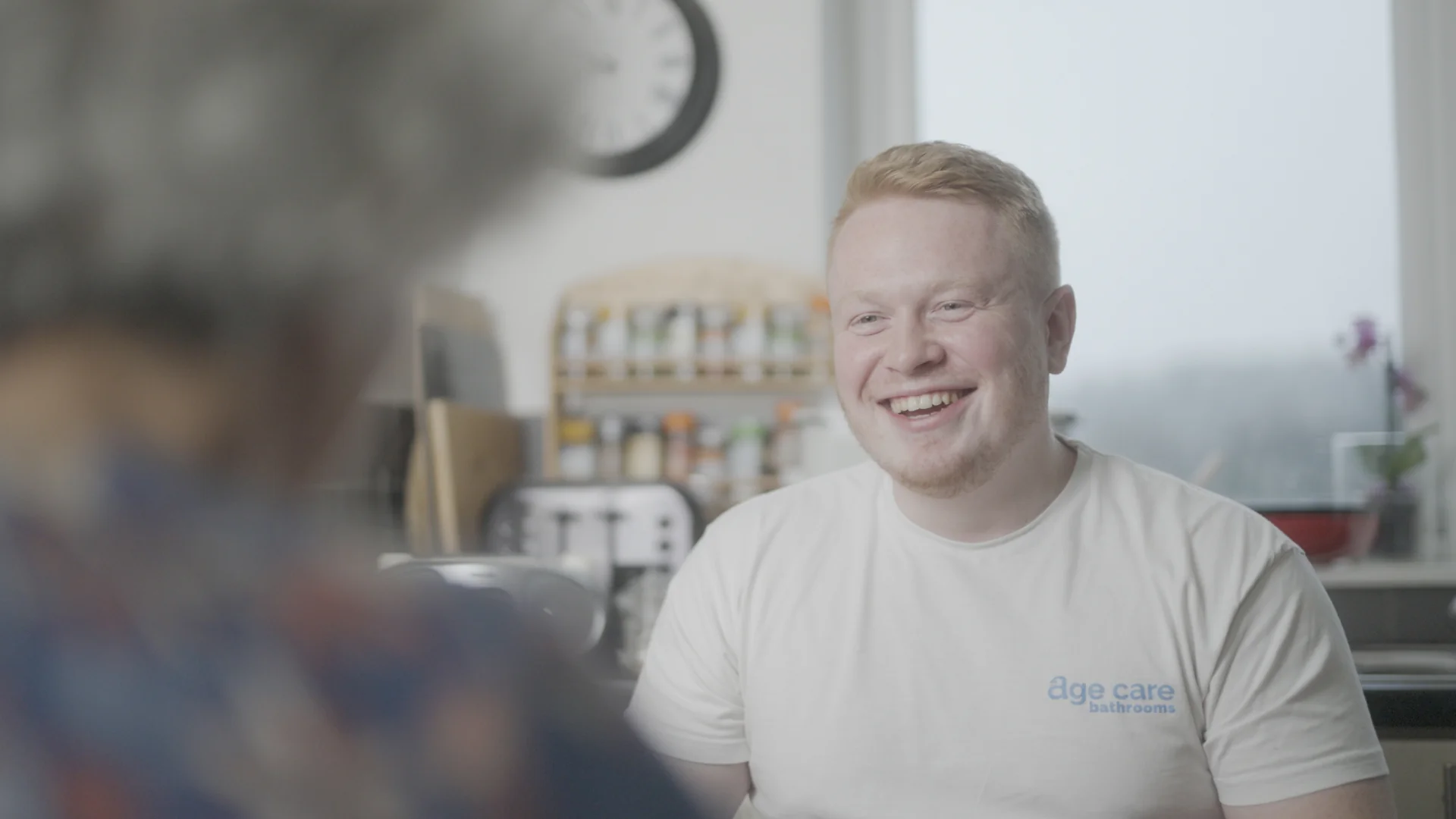 Founder of Age Care Bathrooms, Sam Davies, sat with a customer during a home visit.