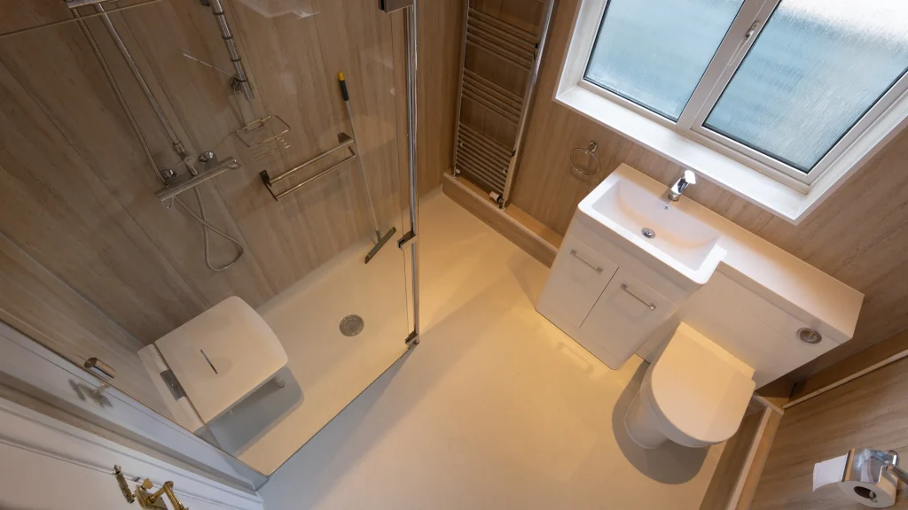 Tom's new level access wet room with showering area, screen, and grab rails.