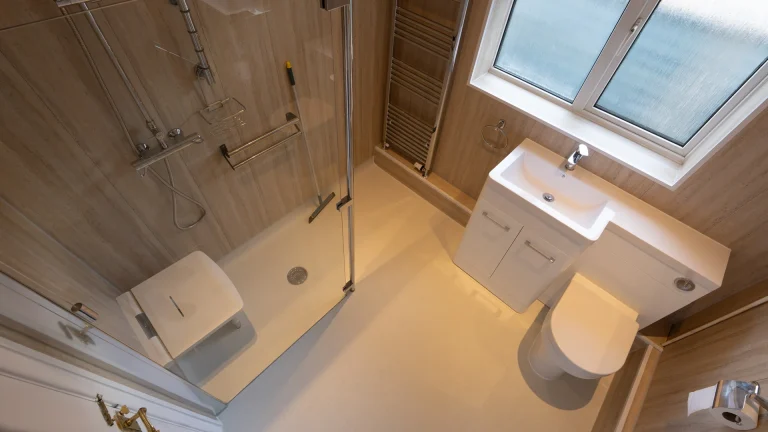 Tom's new level access wet room with showering area, screen, and grab rails.