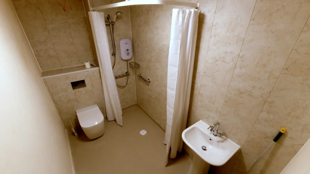 Malcom's level-access bathroom with an electric shower, grab rails, smart toilet and basin