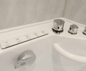 Close-up of the chrome control dials and push-button panel for a whirlpool walk-in bath installed by Age Care Bathrooms, showing easy-to-use accessibility features.